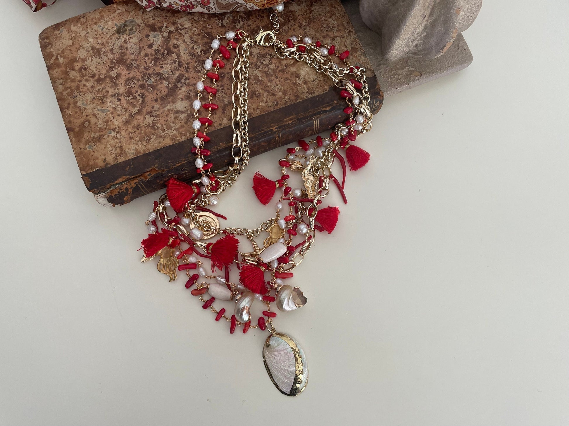 Collana con quattro fili misti, catena a maglia e catena rosario, corallo, conchiglie e nappe. colore rosso.ç