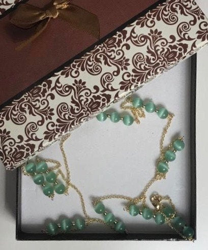 Collana lunga con catena dorata, perle occhio di gatto verde e ciondolo corno in ceramica di Caltagirone.ç