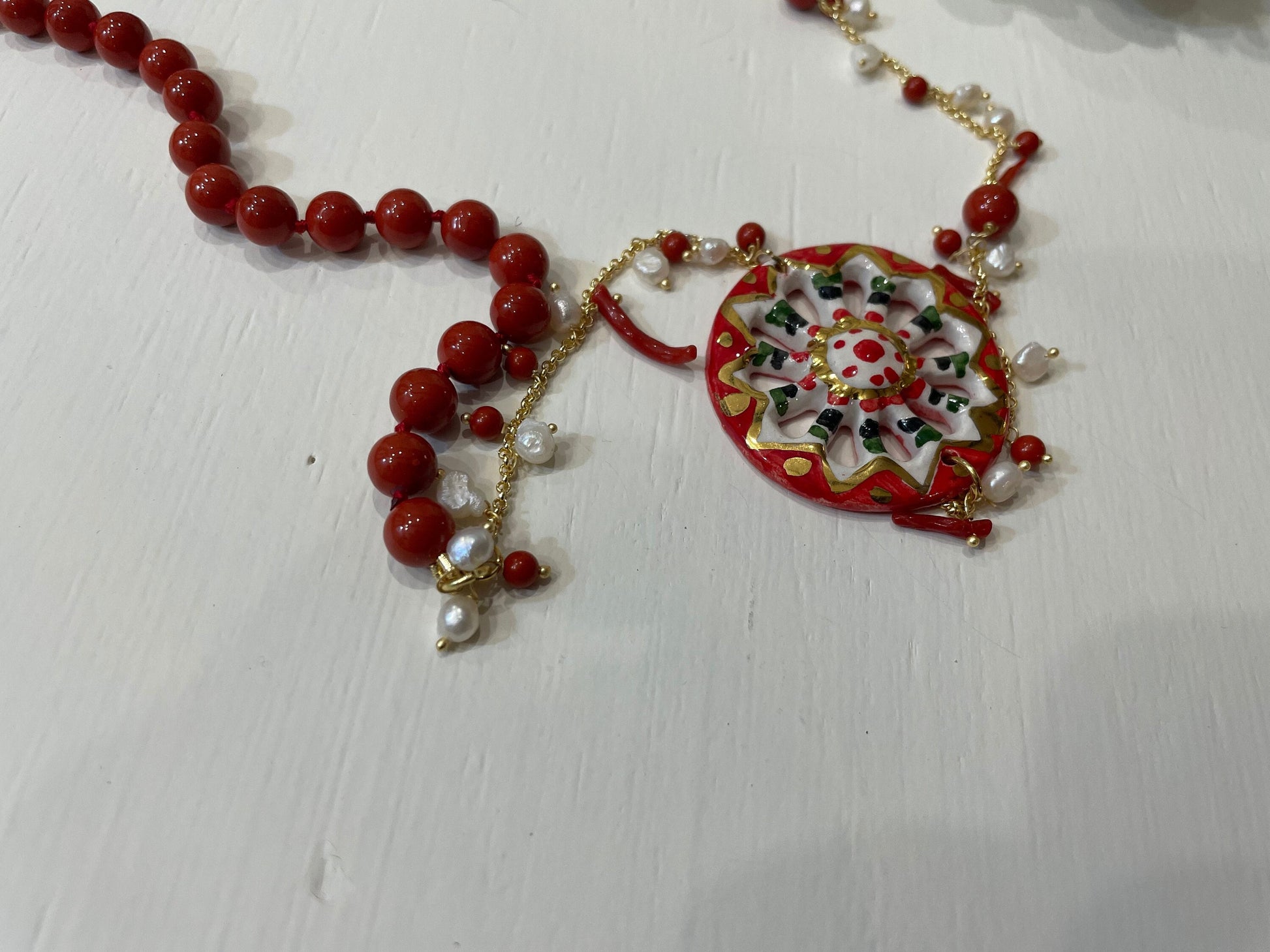 Collana siciliana con ruota di carretto in ceramica di Caltagirone, perle maiorca rosse e corallo. regalo per lei.ç