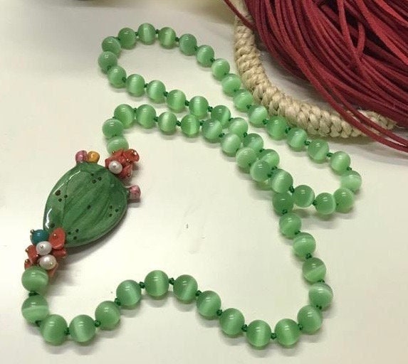 Collana siciliana con filo di perle di occhio di gatto e fico d'india in ceramica di Caltagirone.ç