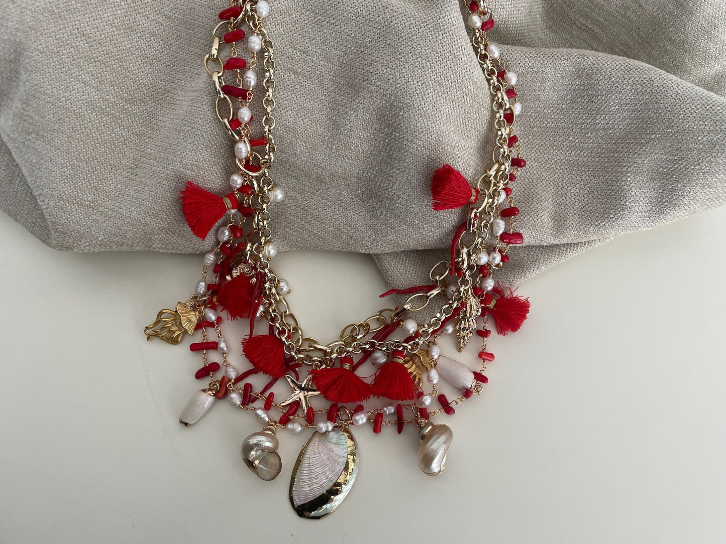 Collana con quattro fili misti, catena a maglia e catena rosario, corallo, conchiglie e nappe. colore rosso.=