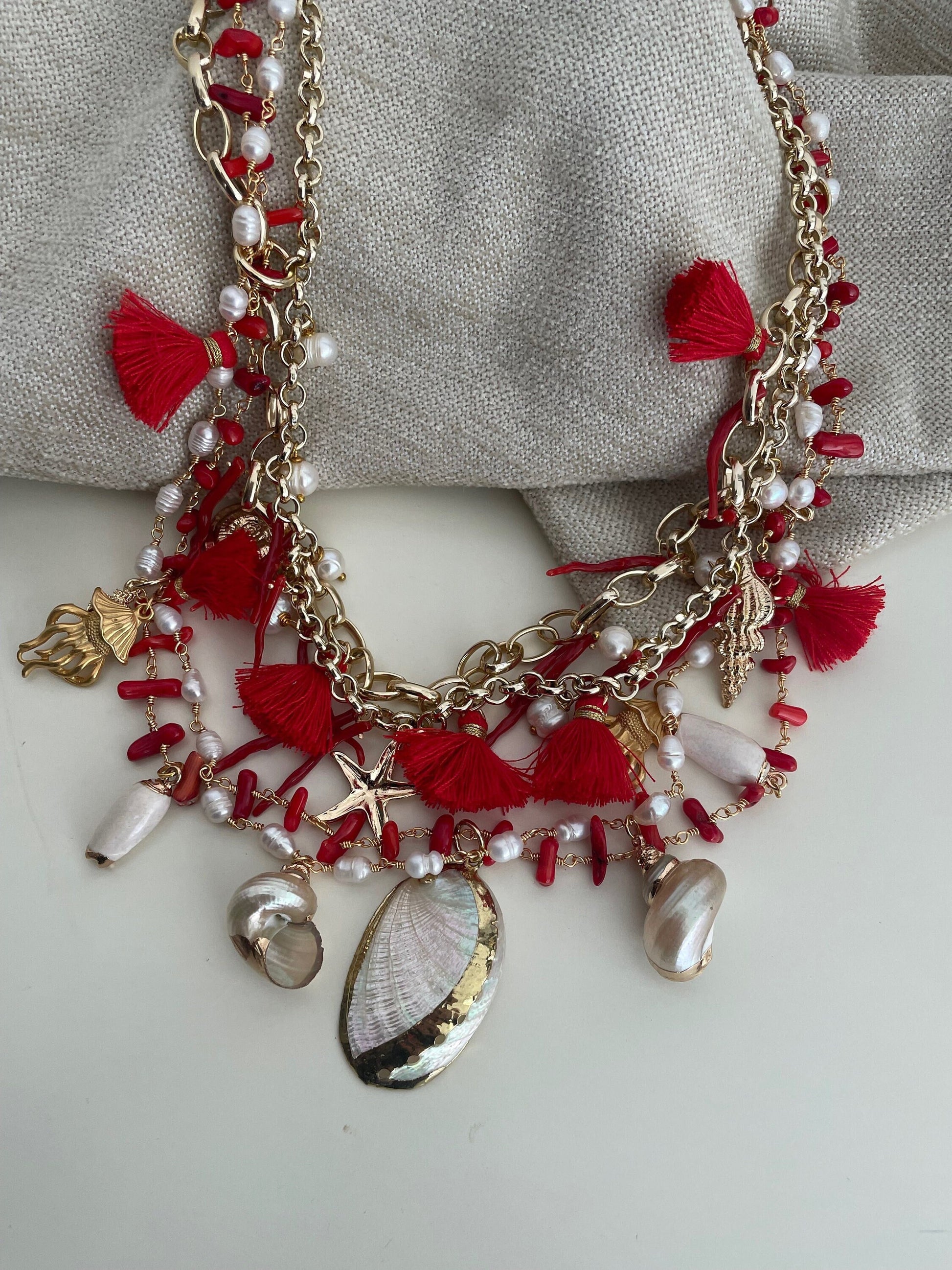 Collana con quattro fili misti, catena a maglia e catena rosario, corallo, conchiglie e nappe. colore rosso.=