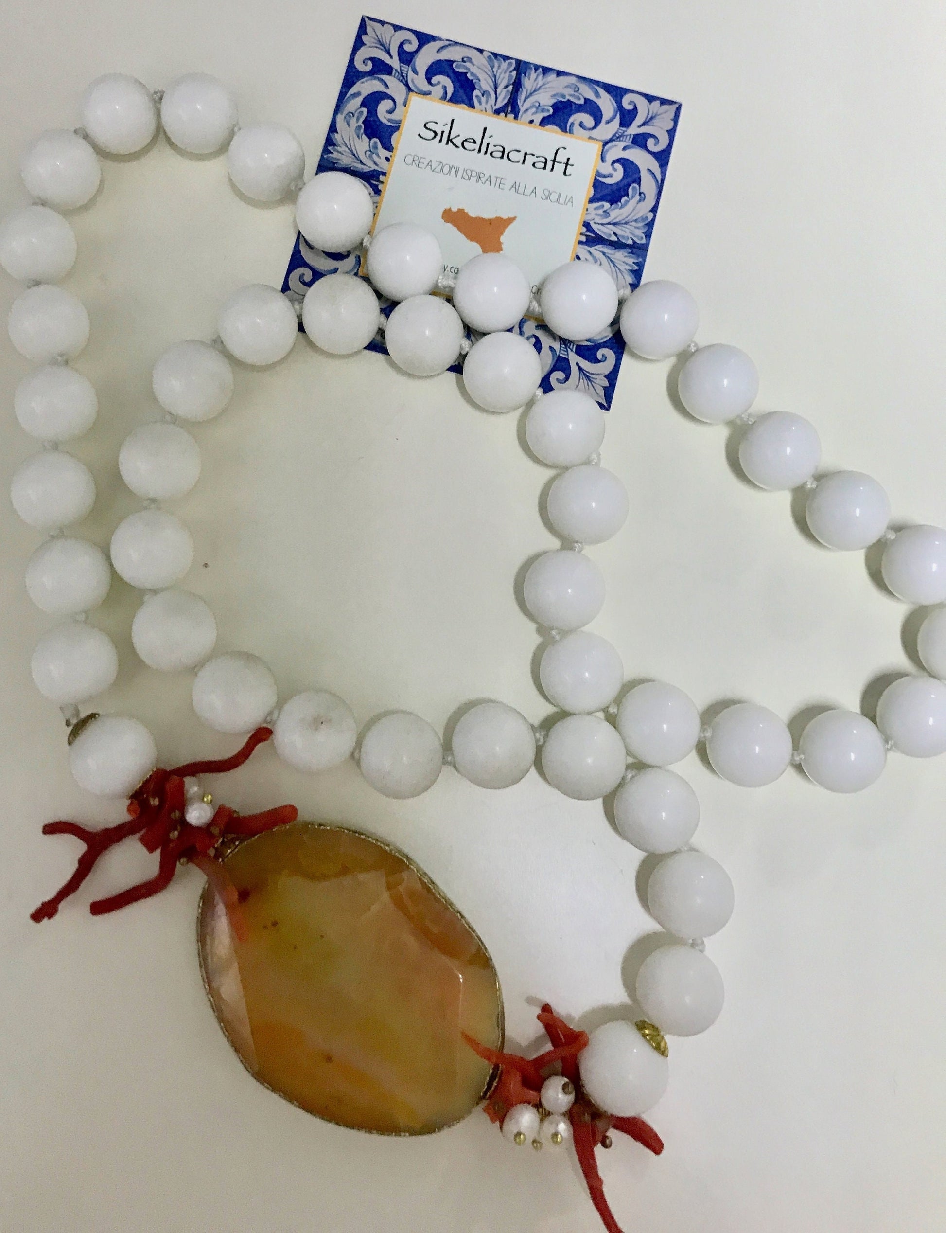 Collana siciliana con filo di perle in agata bianca, medaglione in agata arancione e rami di corallo&