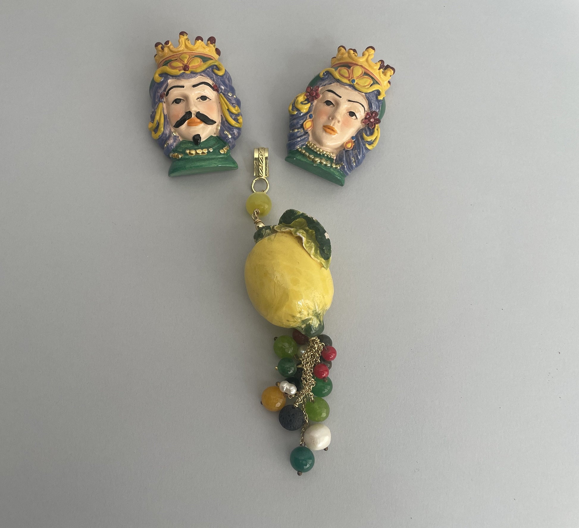 Ciondolo vistoso in ceramica di Caltagirone a forma di limone, decorato con grappolo di perle naturali e perle di Agata verdi e gialle.@