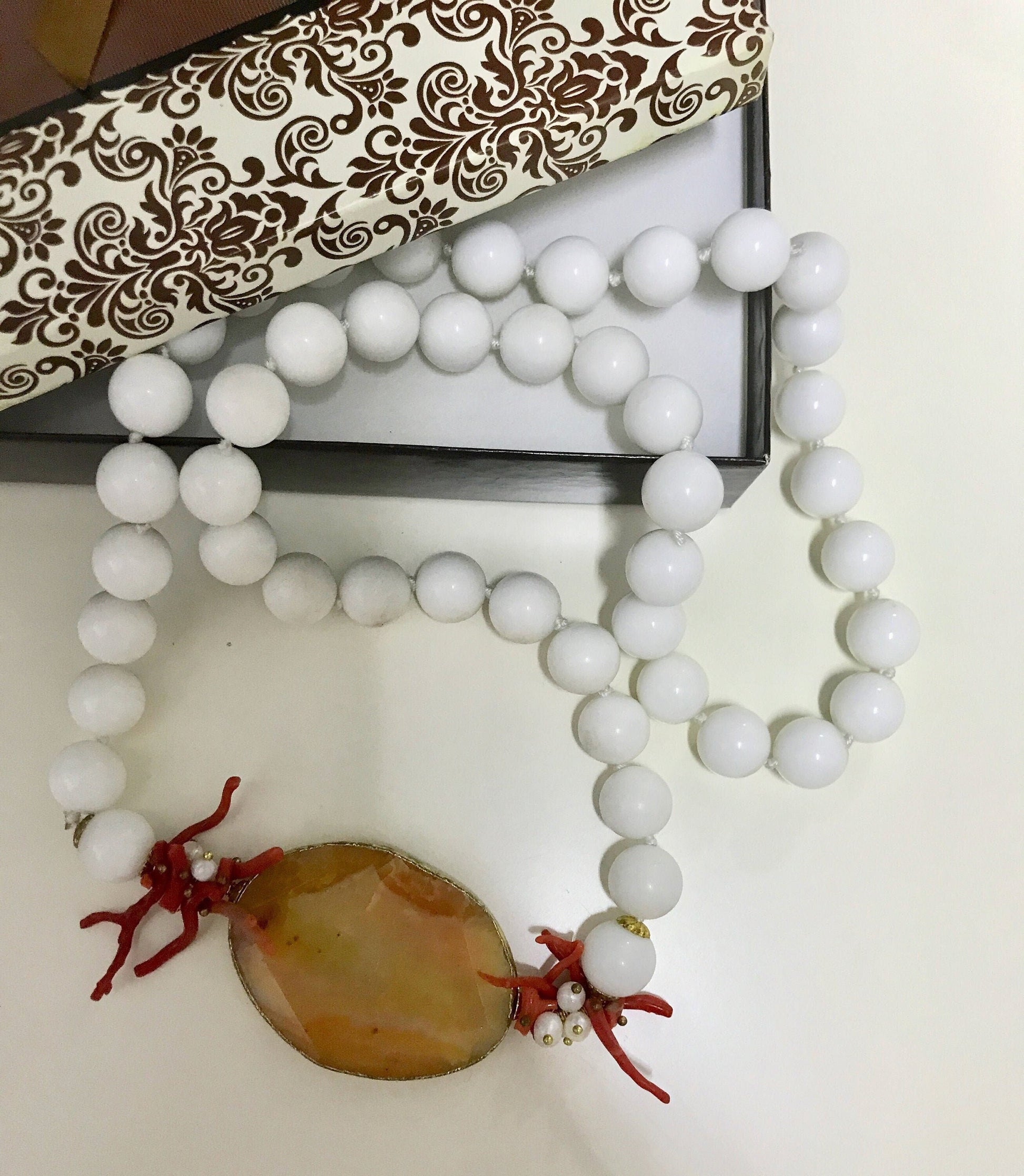 Collana siciliana con filo di perle in agata bianca, medaglione in agata arancione e rami di corallo&