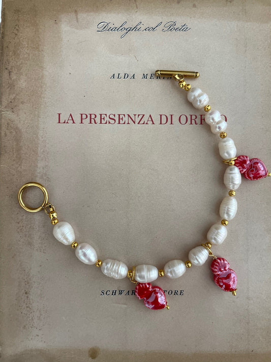 Bracciale con filo di perle di fiume e perline dorate e charms assortiti.)