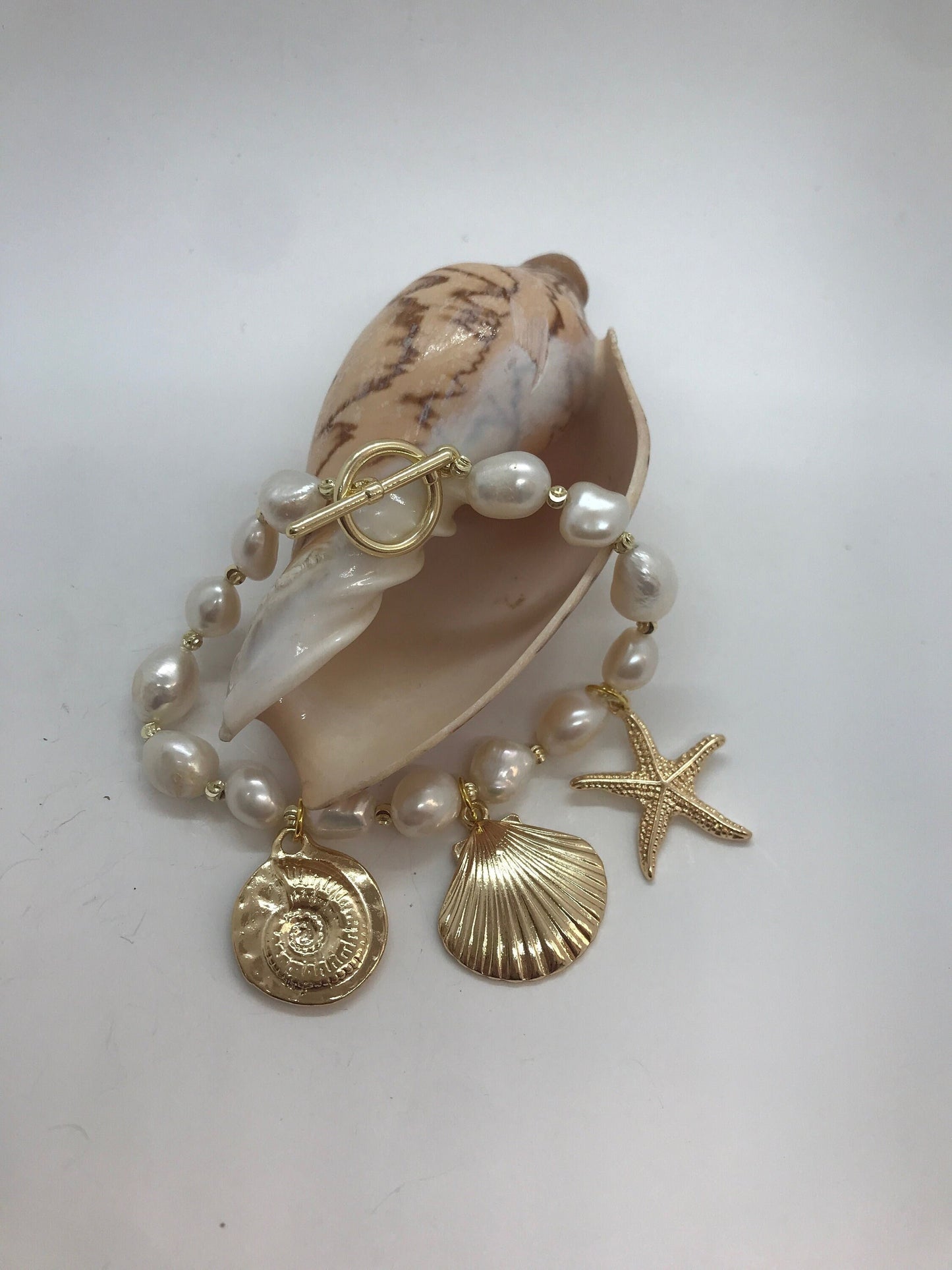 Bracciale perle barocche e piccole perle dorate, bracciale con charms assortiti.)