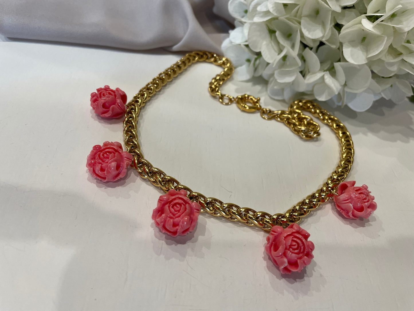 Collana girocollo, con catena a maglia grossa, catena acciaio placcata oro 14k, chocker, 5 pendenti rose in pasta di corallo.=