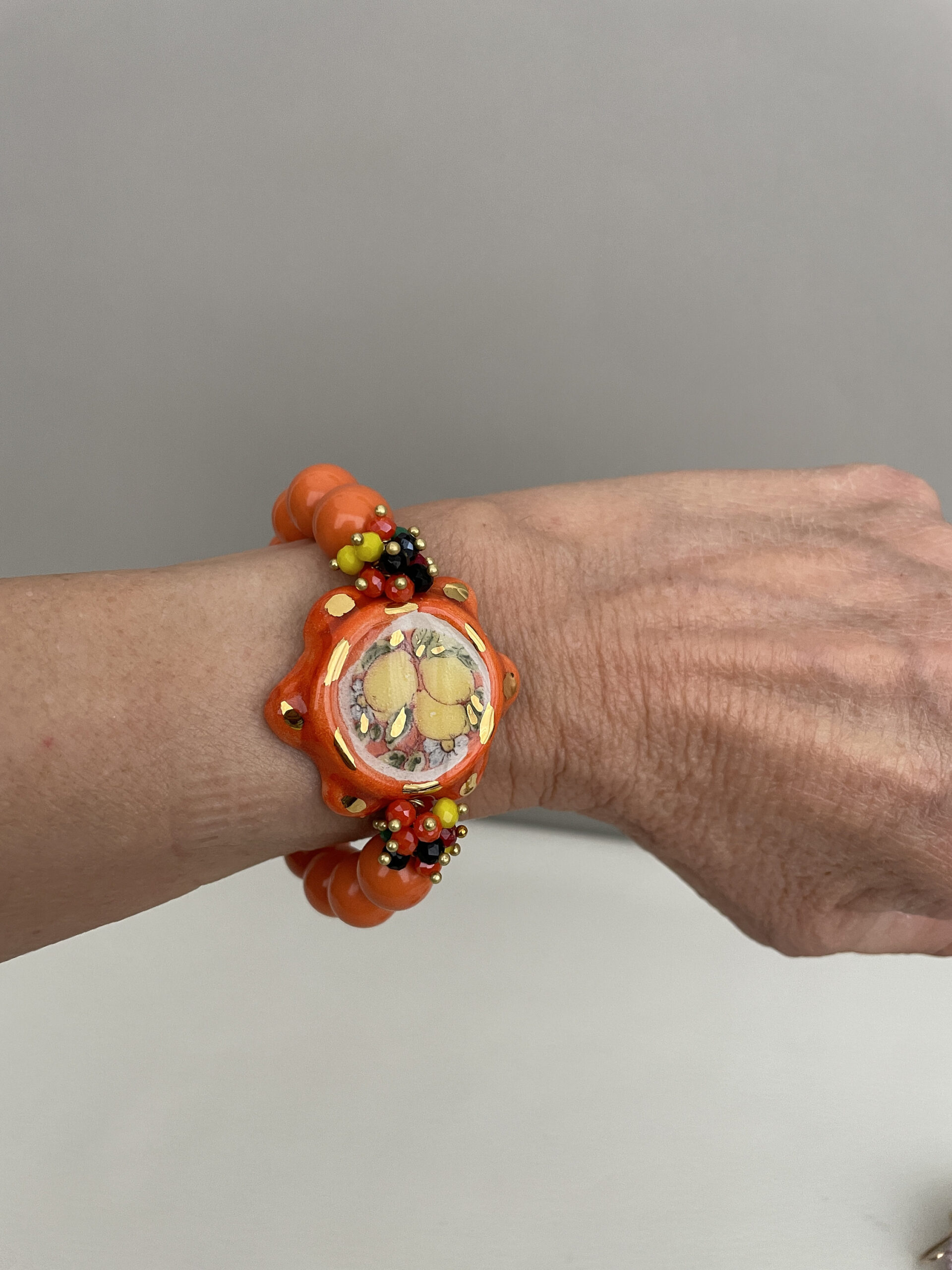 Bracciale Sikelia, bracciale siciliano, tamburello di ceramica Caltagirone, bracciale elastico con perle di pasta di corallo color salmone. Bracciali caratteristici siciliani