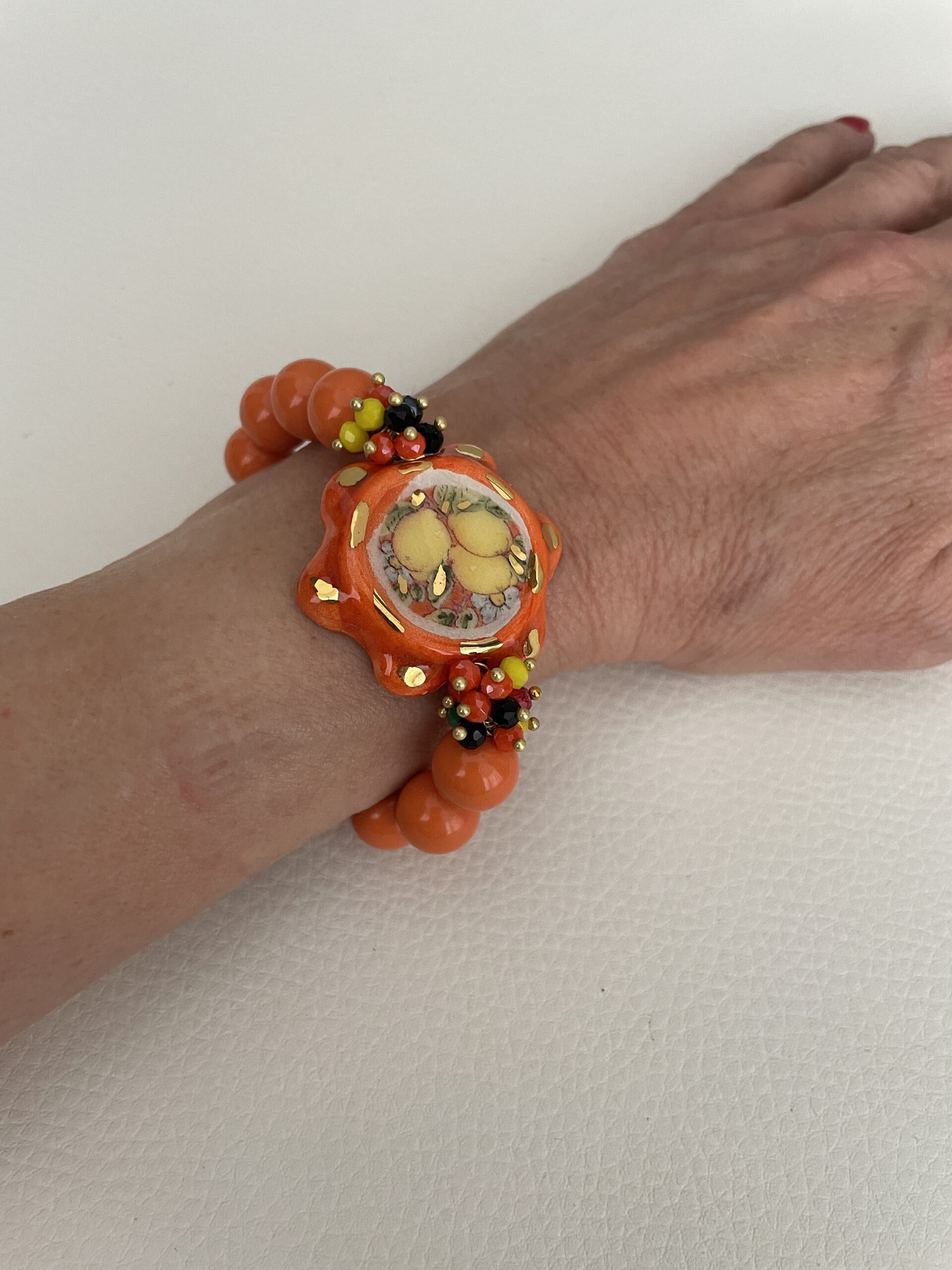 Bracciale Sikelia, bracciale siciliano, tamburello di ceramica Caltagirone, bracciale elastico con perle di pasta di corallo color salmone. Bracciali caratteristici siciliani